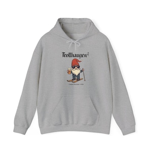 May include: A light gray hoodie featuring a graphic of a gnome skiing with a beer. The gnome wears a red hat and sunglasses. The text "Trollhaugen" is above the graphic, and "Copper Mountain - 2020" is below.