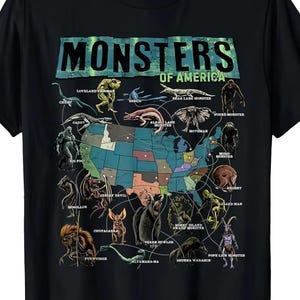 May include: Black t-shirt featuring a map of the United States with illustrations of various monsters. The text "MONSTERS OF AMERICA" is printed across the top in a distressed font. The shirt includes illustrations of cryptids like the Jersey Devil and Mothman.