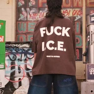 a woman standing in front of a building with graffiti on it