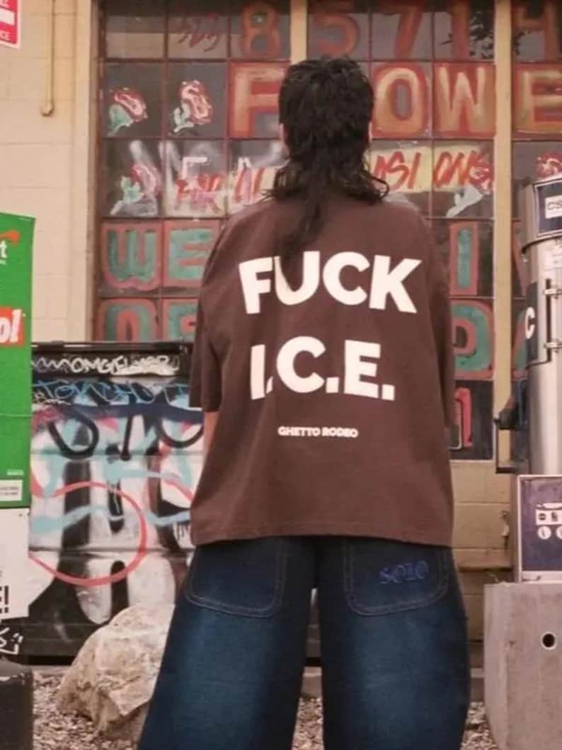 a woman standing in front of a building with graffiti on it