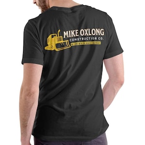 May include: Black t-shirt with a yellow graphic of a bulldozer and the text "MIKE OXLONG CONSTRUCTION CO. WE COME WITH THE BIGGEST EQUIPMENT."