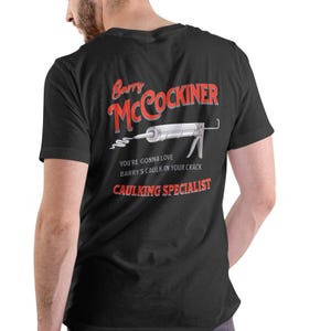 May include: Black t-shirt with a red and white graphic of a caulk gun and the text "Barry McCockiner, You're gonna love Barry's caulk in your crack, Caulking Specialist".