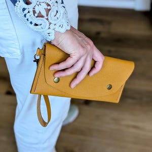 Cartera de mano de piel saffiano color mostaza para mujer, hecha a mano, con cierre de cremallera y correa para la muñeca. Se puede convertir en una billetera larga.