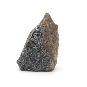 May include: A rough-hewn stone with a dark, metallic, crystalline section contrasted against a rough, brown, earthy portion. The dark section has a reflective, almost glittery appearance, while the brown part has a textured, matte finish.