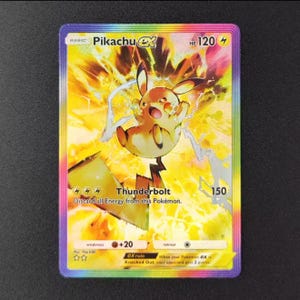 Op de afbeelding: Een holografische Pikachu EX-verzamelkaart. De kaart toont een gele Pikachu-personage met elektrische effecten, de tekst "Thunderbolt" en 120 HP. De kaart heeft een regenboogrand en ligt op een zwart oppervlak.