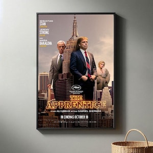 Puede incluir: Cartel de cine para la película "The Apprentice" con Sebastian Stan, Jeremy Strong y Maria Bakalova. El cartel tiene un fondo de ciudad con un gran edificio en el centro. El título de la película está en letras grandes y amarillas.