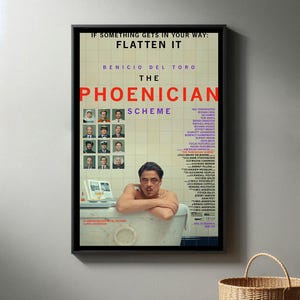Może przedstawiać: Oprawiony plakat filmowy do filmu "The Phoenician Scheme" z Benicio Del Toro. Plakat zawiera tytuł filmu, obsadę i ekipę, z hasłem "If something gets in your way: Flatten it."
