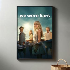 Può includere: Un poster incorniciato con la scritta "we were liars" in alto. Il poster presenta quattro giovani adulti in piedi nell'acqua, con un cielo soleggiato sullo sfondo. Il poster è in una cornice nera.