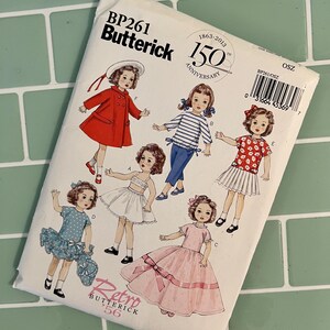 May include: A vintage sewing pattern for making doll clothes. The pattern is for a doll dress, a doll skirt, a doll blouse, and a doll coat. The pattern is from Butterick and is labeled "Retro 56".