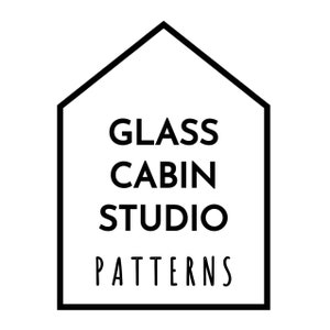 May include: A black and white logo featuring the text "GLASS CABIN STUDIO PATTERNS" inside a house-shaped frame. The text is in a bold, sans-serif font, with the word "PATTERNS" in a handwritten style.