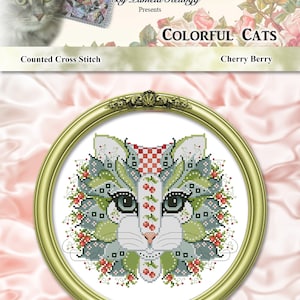 Op de afbeelding: Geteld kruissteekpatroon met een witte kat met groene, rode en blauwe bloemdetails. Het patroon is getiteld "Kleurrijke Katten: Kersenbes" en wordt gepresenteerd door Kitty Me Designs door Pamela Kellogg.