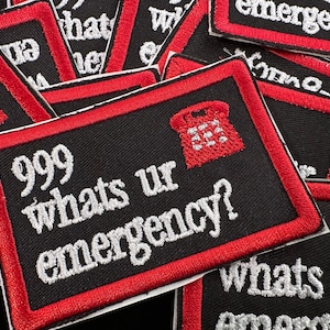 Puede incluir: Parches rectangulares negros con borde rojo y el texto "999 whats ur emergency?" en blanco. También hay un gráfico de teléfono rojo. Los parches están apilados, mostrando el diseño.
