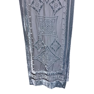 May include: A rectangular dark gray scarf featuring a sheer base fabric with raised velvet-like geometric patterns. The design includes diamond and square shapes with intricate scrollwork and a solid velvet border along the vertical edges.