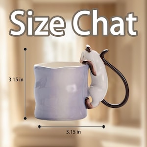 Puede incluir: Una taza de cer&aacute;mica con exterior lila claro y dise&ntilde;o de gato blanco. El gato es marr&oacute;n y blanco y parece estar trepando por la taza. La taza mide 8 cm de ancho y 8 cm de alto. El texto "Size Chat" est&aacute; en la parte superior.