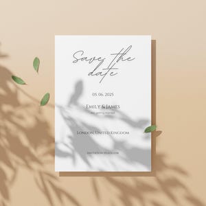 May include: A white save the date card with the text "Save the date" in a handwritten font. The date "05.06.2025" is printed below the text. The names "Emily & James" are printed below the date, followed by the text "Are getting married". The location "LONDON, UNITED KINGDOM" is printed below the names. The text "Invitations to follow" is printed at the bottom of the card.