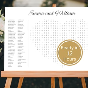 May include: A white wedding sign on a wooden easel featuring the names Emma and William in black script, a list of words, and a heart-shaped word search puzzle. A gold circular badge on the sign displays the text Ready in 12 Hours in white.