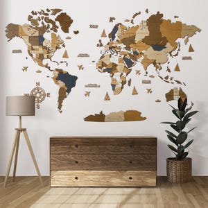 Peut inclure: Une carte du monde en bois avec un schéma de couleurs brun clair et brun foncé. La carte est montée sur un mur blanc et comprend une boussole, des avions et des voiliers. Une commode en bois avec trois tiroirs se trouve au premier plan.