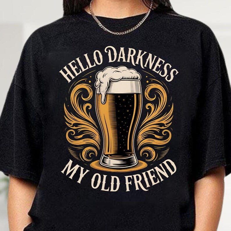 A black t-shirt with a graphic design featuring a beer glass and the text "HELLO DARKNESS MY OLD FRIEND" printed on it.