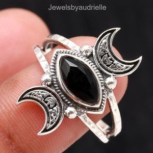 Könnte beinhalten: Silberring mit einem schwarzen Onyx-Edelstein und einem dreifachen Halbmond-Design.