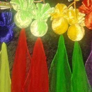 May include: A selection of small, colourful velvet pouches with matching sheer fabric cones. The pouches are in shades of blue, green, yellow, and orange. The sheer fabric cones are in shades of pink, yellow-green, red, green, and purple.