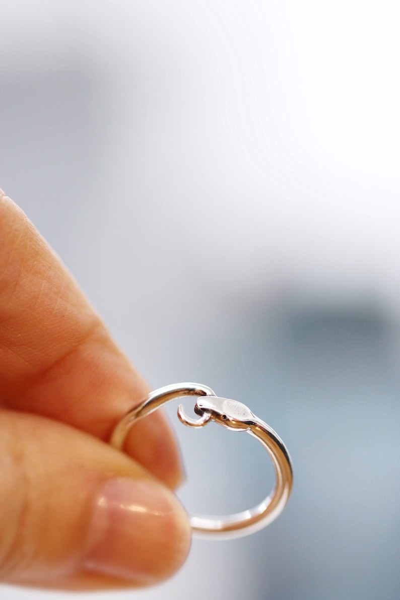 Puede incluir: Un anillo de plata con un dise&ntilde;o &uacute;nico que presenta una peque&ntilde;a forma curva en el lateral.