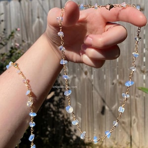 May include: A gold-toned chain necklace and matching bracelet set featuring small, irregular, translucent white opal-like stone chips spaced evenly along the links. The jewelry pieces include a lobster claw clasp and the text ichigoem.etsy.com.