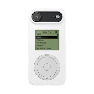 May include: A white digital music player with a circular navigation wheel and a screen displaying a playlist titled Road Trip with tracks including Yeah!, Toxic, This Love, The Reason, Hey Ya!, and She Will Be Loved. A camera lens is at the top.