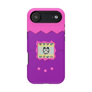 May include: A purple and pink phone case with a retro digital pet design. The case features a pixelated character on a small screen, with a pink zig-zag design separating the pink and purple sections. Three pink buttons are at the bottom.