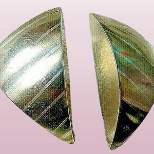 May include: A pair of silver earrings with a geometric, triangular shape and a striped pattern.