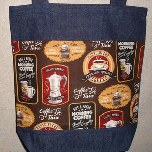 May include: A brown and red fabric tote bag with a denim trim. The fabric features a repeating pattern of coffee mugs, coffee grinders, and coffee pots with the text "Coffee & Time", "Hot & Fresh Morning Coffee Served Everyday", "Premium Quality Coffee", "Locally Brewed", "House Blend", and "100% Natural Freshly Ground".