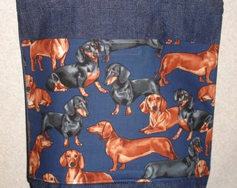May include: A blue denim tote bag with a fabric lining featuring a repeating pattern of dachshund dogs in black, brown, and tan colors on a blue background.