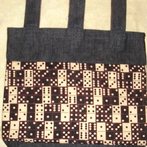 May include: A denim tote bag with a black and white domino pattern fabric lining. The bag has three denim straps.
