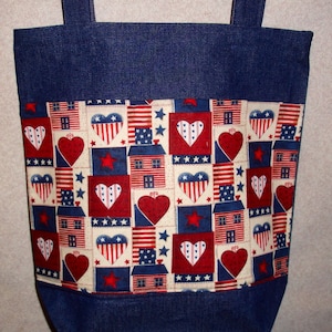 May include: A blue denim tote bag with a red, white, and blue patchwork fabric lining. The lining features hearts, stars, and houses.