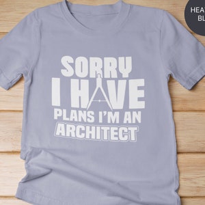 Puede incluir: Una camiseta azul jaspeada con un gráfico blanco que dice "Lo siento, tengo planes, soy arquitecto" con un compás y un transportador.