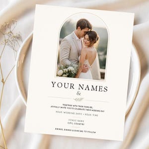 Puede incluir: Una tarjeta de invitación de boda rectangular con fondo crema y un marco de fotos central en forma de arco que muestra a una pareja. El texto incluye "YOUR NAMES &", "TOGETHER WITH THEIR FAMILIES", "YOUR WEDDING DATE - YOUR TIME", "VENUE NAME", "CITY, COUNTRY" y "DINNER, DRINKS & DANCING TO FOLLOW".