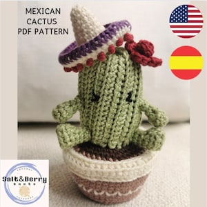 May include: Crocheted cactus wearing a purple and white sombrero with red pom-poms. The cactus is in a brown and cream pot. The image includes the text "MEXICAN CACTUS PDF PATTERN".