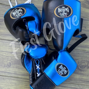 Peut inclure: Un ensemble d'équipement de boxe noir et bleu, comprenant un casque et des gants. Les gants ont des lacets blancs. Le texte "NO BOXING NO LIFE" est visible sur le casque et les gants.