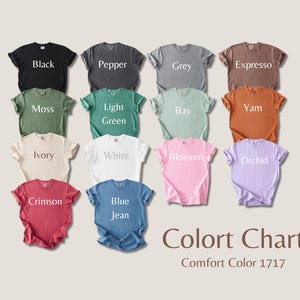 Op de afbeelding: Een kleurenkaart van Comfort Color 1717 t-shirts in verschillende kleuren, waaronder zwart, peper, grijs en espresso. Andere kleuren zijn mos, lichtgroen, baai en yam. Extra kleuren zijn ivoor, wit, bloesem en orchidee. Karmozijnrood en spijkerbroekblauw zijn ook afgebeeld.