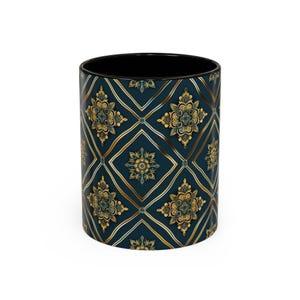 Puede incluir: Una taza de cerámica con interior negro y exterior verde azulado oscuro. El exterior presenta un patrón repetido de diseños florales dorados y verde azulado dentro de una cuadrícula de diamantes. La taza es cilíndrica y mide unos 10 cm de alto.