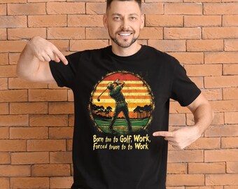 Może przedstawiać: Czarny T-shirt z grafiką w stylu vintage przedstawiającą golfistę zamachującego się kijem. Grafika umieszczona jest na tle zachodu słońca z palmami. Tekst na koszulce brzmi "Born too to Golf, Work, Forced tovon to to Work".