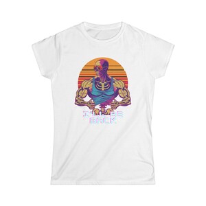 Pode incluir: Camiseta branca com uma ilustração retrô de um esqueleto musculoso usando óculos de sol e uma regata azul, contra um fundo de pôr do sol. O texto "I'LL BE BACK" é exibido abaixo.