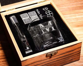 May include: A wooden box with a glass whiskey tumbler, ice stones, and a whiskey stone tong. The tumbler is engraved with the name "Michael" and the letter "M".