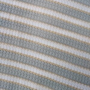 May include: Close-up of a white and light gray striped fabric with a subtle textured pattern.