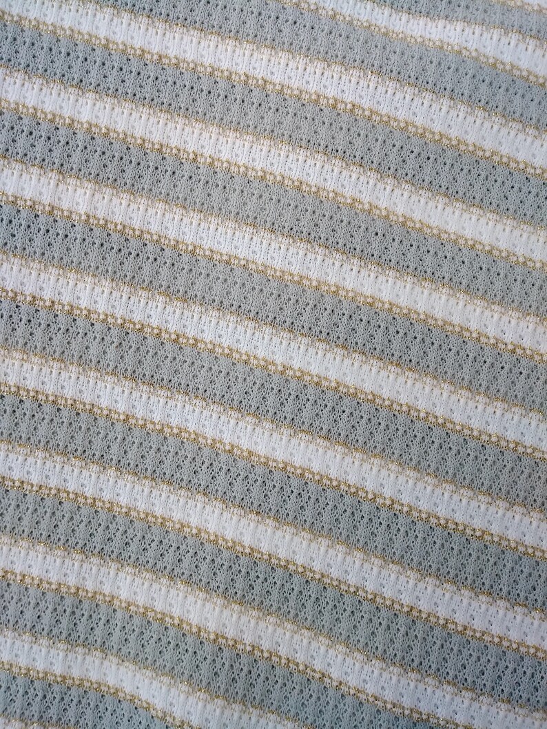 May include: Close-up of a white and light gray striped fabric with a subtle textured pattern.
