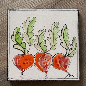 Puede incluir: Una obra de arte cuadrada pintada a mano con tres rábanos en forma de corazón. Los rábanos son de color naranja-rojo con hojas verdes y tallos negros, sobre un fondo blanco con un borde negro. La obra está sobre un lienzo cuadrado.