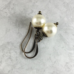 May include: A pair of antique gold dangle earrings with large white pearl beads.