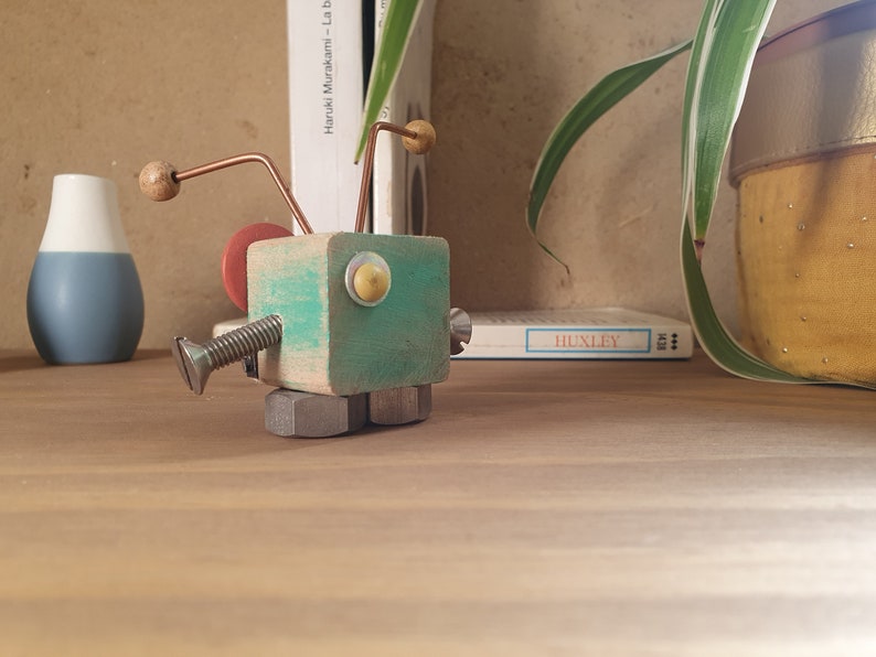 Pequeña criatura robot hecha de madera y metal reciclados imagen 2