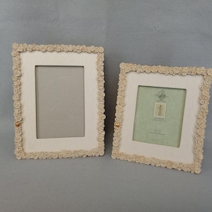 May include: Two rectangular picture frames with off-white fabric borders decorated with small sculpted rosettes. Each frame features a single gold-colored heart accent on the left side. The right frame contains a Willow Tree insert with 4 x 5 inch text.