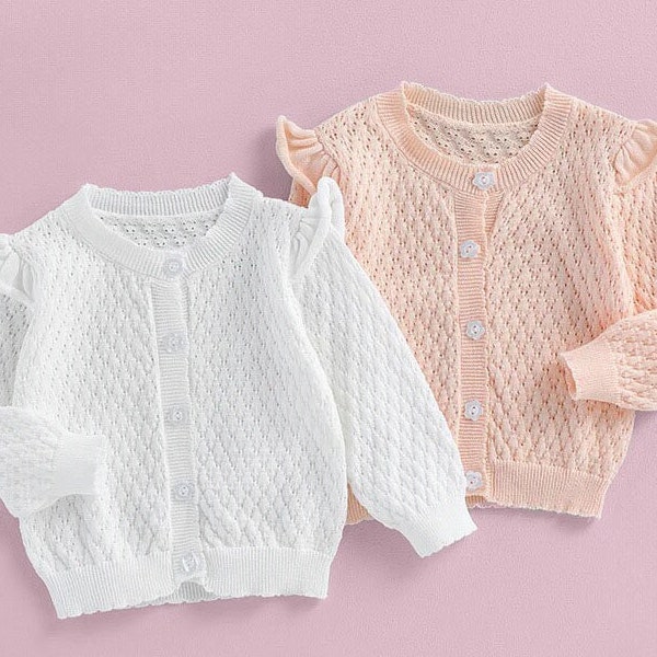 Schattige gebreide trui met lange mouwen en knopen voor kinderen. Herfst-winterkleding in roze en wit. Gezellige trui. Mode voor kinderen. Warme kleding