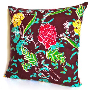 May include: A brown throw pillow with a floral pattern featuring red, yellow, and green flowers on a brown background.